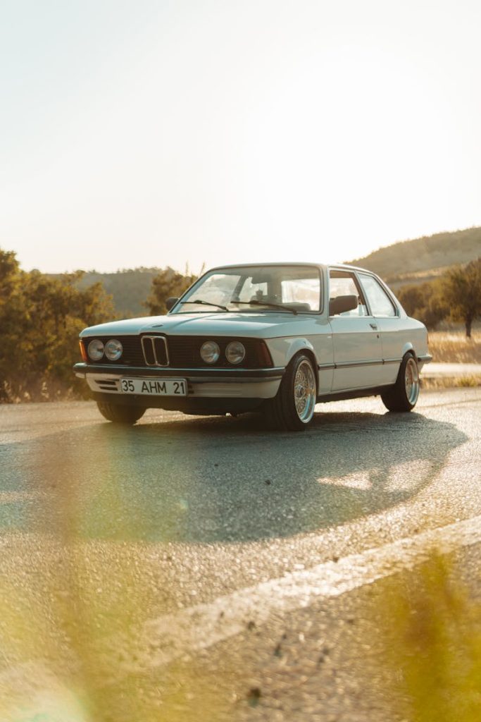 Vintage BMW parked outdoors on a sunny road in İzmir, Türkiye, capturing a timeless automotive elegance.